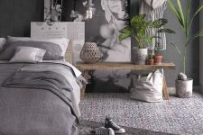 a grey bedroom with graphite grey walls, grey and white textiles and mosaic tiles on the floor and potted greenery
