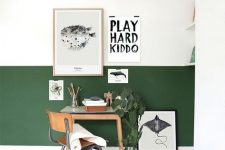 a modern color block home office with a hunter green and white wall, stylish furniture and a gallery wall and a potted plant