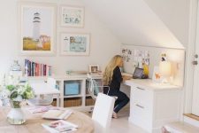 a neutral attic home office with a large L-shaped desk, a gallery wall, a round table, colorful books and baskets