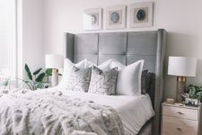 a neutral bedroom infused with soft greys – an upholstered grey bed, a fur rug and lamps, a fur blanket