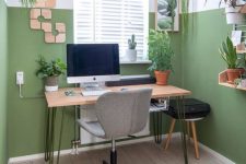 a neutral modern home office with color block green walls, mid-century modern furniture, potted plants and wooden decor