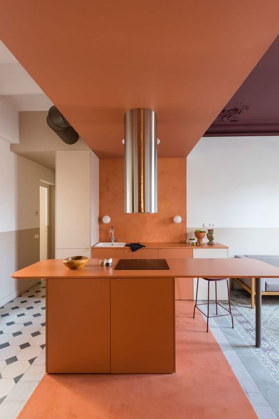 a refined burnt orange kitchen with sleek matte cabinets, white ones, a burnt orange roof and a shiny metal hood