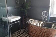 a retro-inspired black and white bathroom spruced up with a gorgeous vintage copper tub and a potted plant
