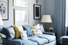 a romantic pastel blue living room with everything in light blues and a chic gallery wall with gold touches