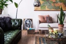 a stylish eclectic living room with a green leather tufted sofa and a more neutral couch for a contrast