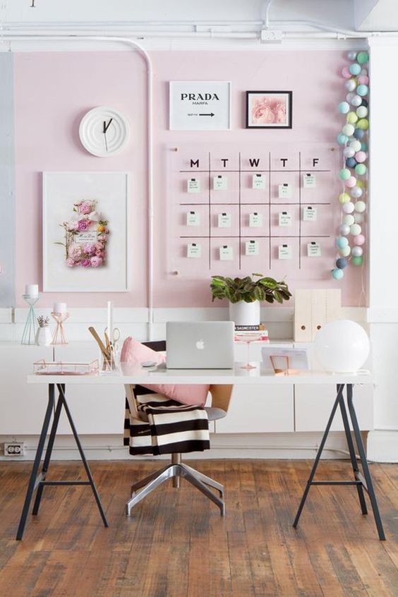 a stylish feminine home office with a light pink accent niche, a memo board, a trestle desk and a chair plus chic accessories