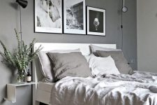 a stylish grey Scandinavian bedroom with grey walls, white minimal furniture, a grey fur rug, a geometric pendant lamp and a gallery wall
