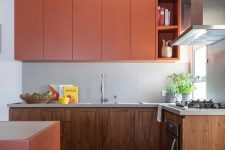 a stylish kitchen with sleek orange uppers and wooden lower cabinets and an orange kitchen island looks very trendy