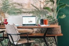 a stylish tropical home office with a tropical wall mural, a wooden desk and a bench, potted plants and woven elements