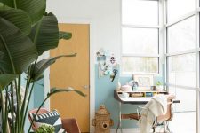a tropical-infused home office with color block walls, mid-century modern furniture, potted plants and a woven basket