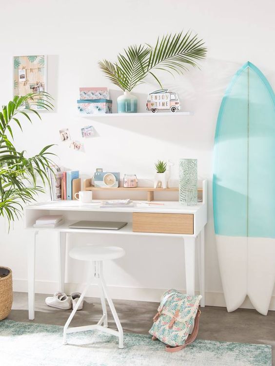 a tropical pastel home office with a shabby green rug, a color block surfing board and potted greenery