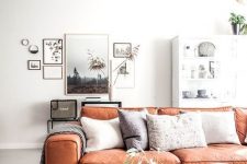 an airy and chic living room done in neutrals with a bright amber leather sofa is very cool and welcoming