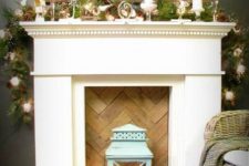 03 a faux fireplace with a chevron wooden screen, a crate with pinecones, candles, fir brnahces and a blue lantern