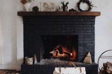 07 a black brick fireplace with a wooden mantel with various plants and some accessories plus a firewood stand next to it