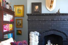 08 a black brick fireplace with pillar candles and hands, with a faux deer head over it is very cool and bold