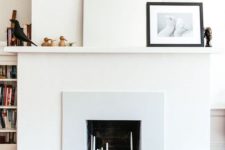 09 a neutral minimal faux fireplace with lots of various candles inside and very laconic and minimal decor on the mantel