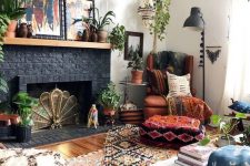 12 a boho living room with a black brick fireplace and a wooden mantel, with lots of potted plants and bold boho artworks