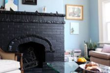 16 a pastel and neutral living room with a bold statement – a black brick fireplace with geometric figurines inside