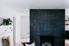 17 a neutral mid-century boho living room with a black brick fireplace that echoes with the furniture