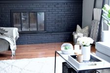 18 a modern neutral farmhouse living room with a black brick fireplace that contrasts it and a wooden wall over it