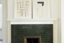 23 a hunter green brick fireplace with copper detailing and abstract artworks on the mantel looks very elegant and refined