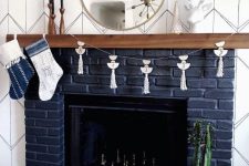 25 a navy brick fireplace with a wooden mantel and some metallic chess inside is a very fresh take on a traditional piece