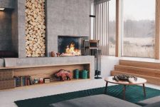 a bold and cool modern living room with a large concrete fireplace and a niche for storing firewood is very welcoming