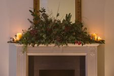 a lovely fireplace decorated with evergreens