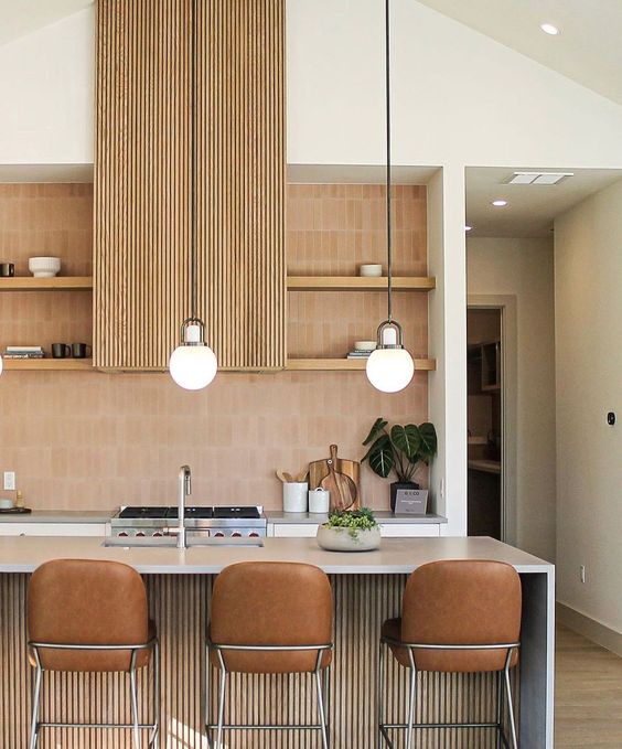 a chic and beautiful contemporary kitchen with white cabinets, a stained fluted kitchen island and a matching hood, a terracotta stacked tile backsplash