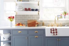 a chic slate grey farmhouse kitchen with a grey subway tile backsplash and a mosaic tile floor is elegant