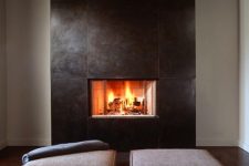 a clean and modern fireplace with sleek metal sheets that surround it and a couple of minimal cushions is a stylish idea