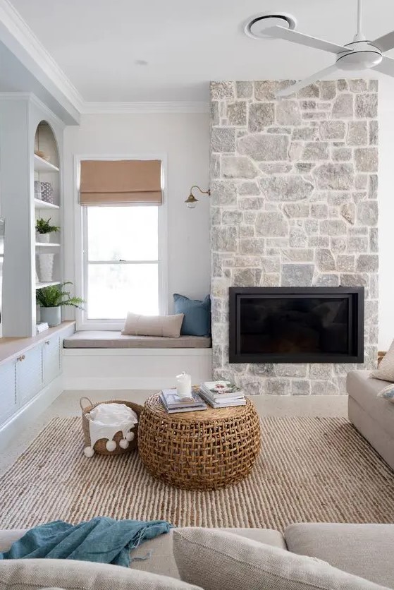 a contemporary living room with a built-in fireplace, grey seating furniture, a jute rug, niche shelves and greenery