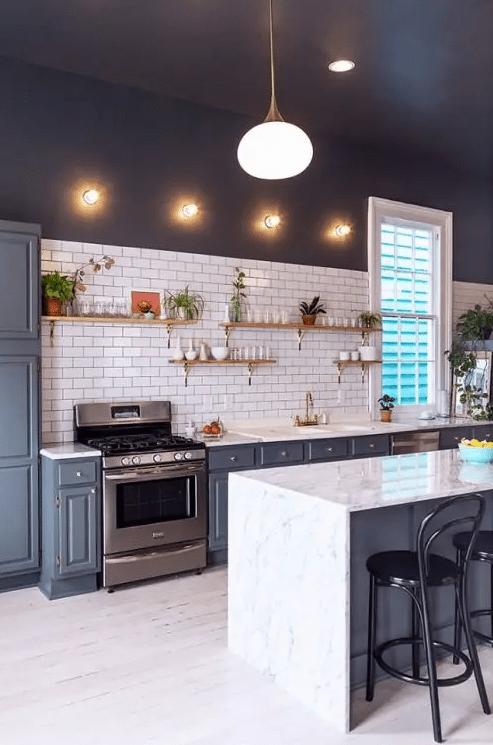 a contrasting kitchen with dark walls, a white subway tile backsplash, grey cabinets and open shelves plus lights
