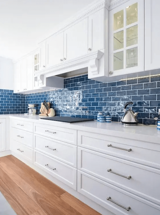 a cute kitchen with a blue backsplash