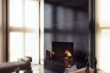 a gorgeous black steel clad fireplace with accenting screws is a beautiful statement decor feature