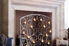 a gorgeous ornate metal screen with small candles is a chic and refined touch to your fireplace that will look like no other