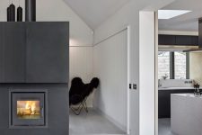 a hearth clad with dark metal makes a bold statement in this open layout and it’s visible from all sides