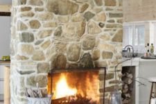 a large stone fireplace separates the kitchen and the living room and makes both of them cozier and warmer