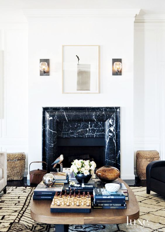a luxurious living room with a faux fireplace clad with black marble that brings more chic to the space