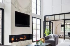 a luxurious living room with a large marble slab with a built-in fireplace and a TV is the centerpiece of the room