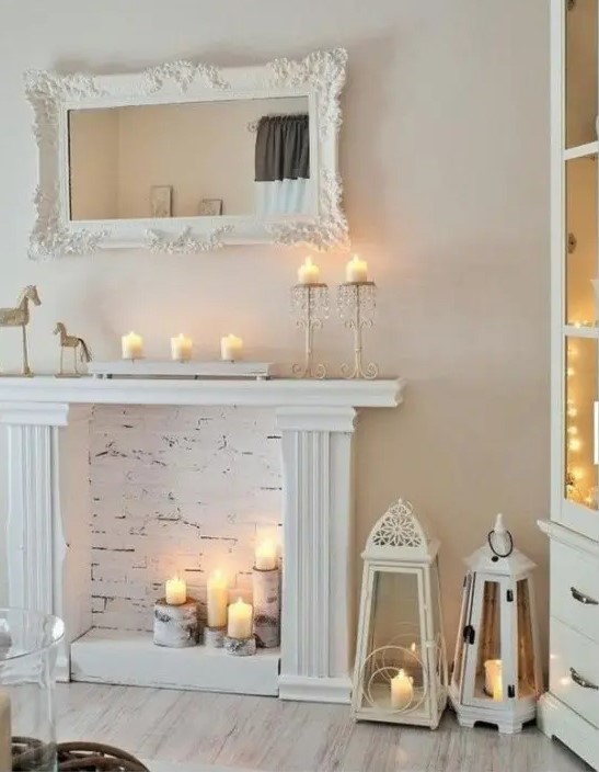 a modern candelabra on the mantel and tree stumps with candles in the fireplace