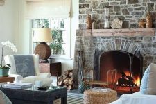 a neutral and chic living room with a stone fireplace that becomes a centerpiece, adds interest and texture to the space