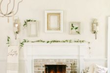 a neutral and cozy space with a fireplace with pillar candles, a rug, a basket with pillows, evergreens and empty frames
