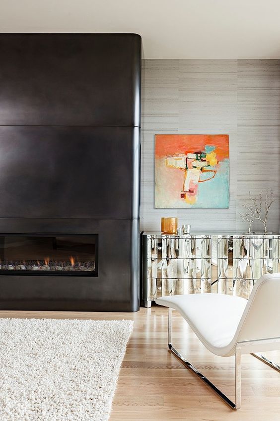 a neutral and sophisticated living room accented with a fireplace clad with blackened steel sheets for a sleek and ultra modern look