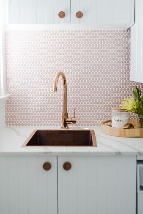 a neutral kitchen with a pink penny tile backsplash and rose gold fixtures for a lovely and chic look