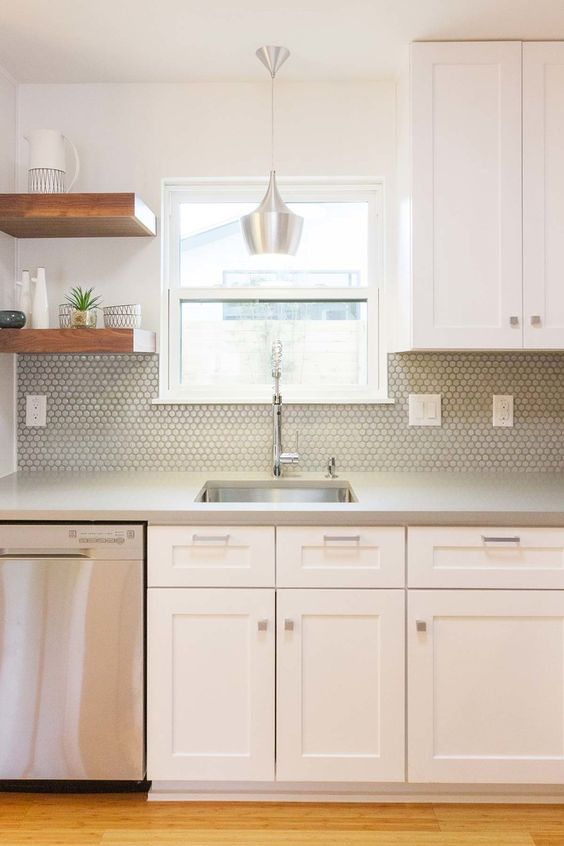 a neutral mid-century modern kitchen with concrete countertops, a grey penny tile backsplash and open shelving