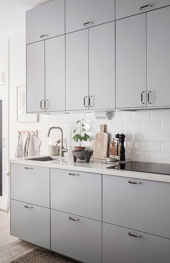 a cute grey kitchen with a white backsplash