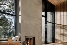 a refined minimalist living room with a concrete fireplace, neutral furniture, wooden walls and ceiling plus glazed walls
