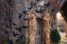 a rustic house entrance with corn husks, pumpkins and bats is a lovely space to enjoy