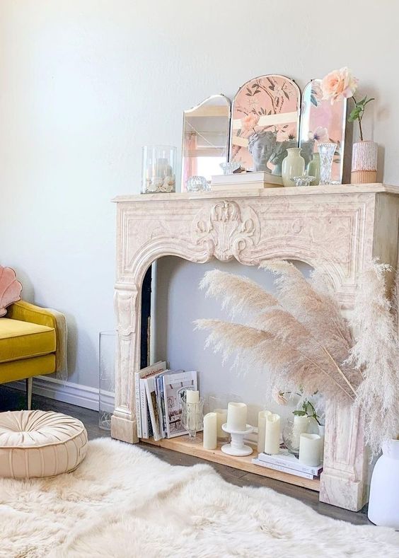 a vintage French mantel with pillar candles, books, a mirror and some more pastel decor is a cool idea for a delicate space
